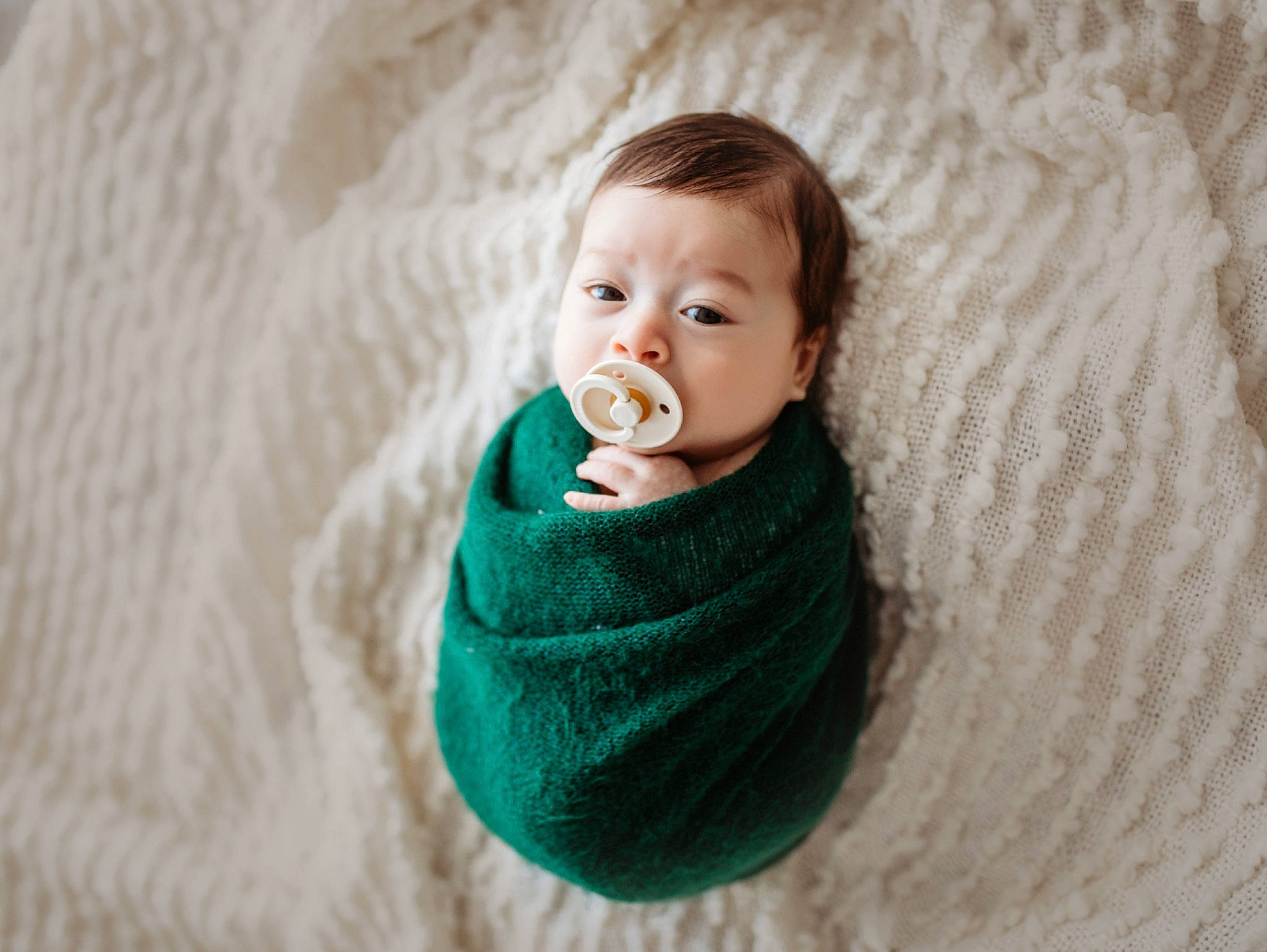 Jett is registered to the contest to win money with this photo: baby, baby_toddler_clothing, button, cheek, comfort, craft, knitting, linens, person, photography, skin, sweater, teal, textile, thread, toddler, wool, woolen