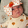baby, infant, face, headwear, bow, polka_dots, pumpkin, halloween, clothing, onesie, cute, expression, lying_down, blanket, soft_texture, orange, white, child, portrait, indoor
