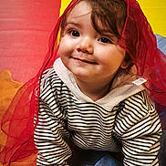 Nahel participe au concours pour gagner de l'argent avec cette photo : toddler, child, smile, face, striped_clothing, hoodie, red_scarf, crawling, colorful_background, yellow, red, blue, playmat, curly_hair, cute, indoors, happy, portrait, baby, person