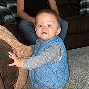 November joined the competition — help win amazing prizes! toddler, child, man, tattoo, couch, carpet, blue_vest, gray_clothing, polka_dot, living_room, furniture, person, indoor, family, curious, standing, casual, home, portrait, cozy