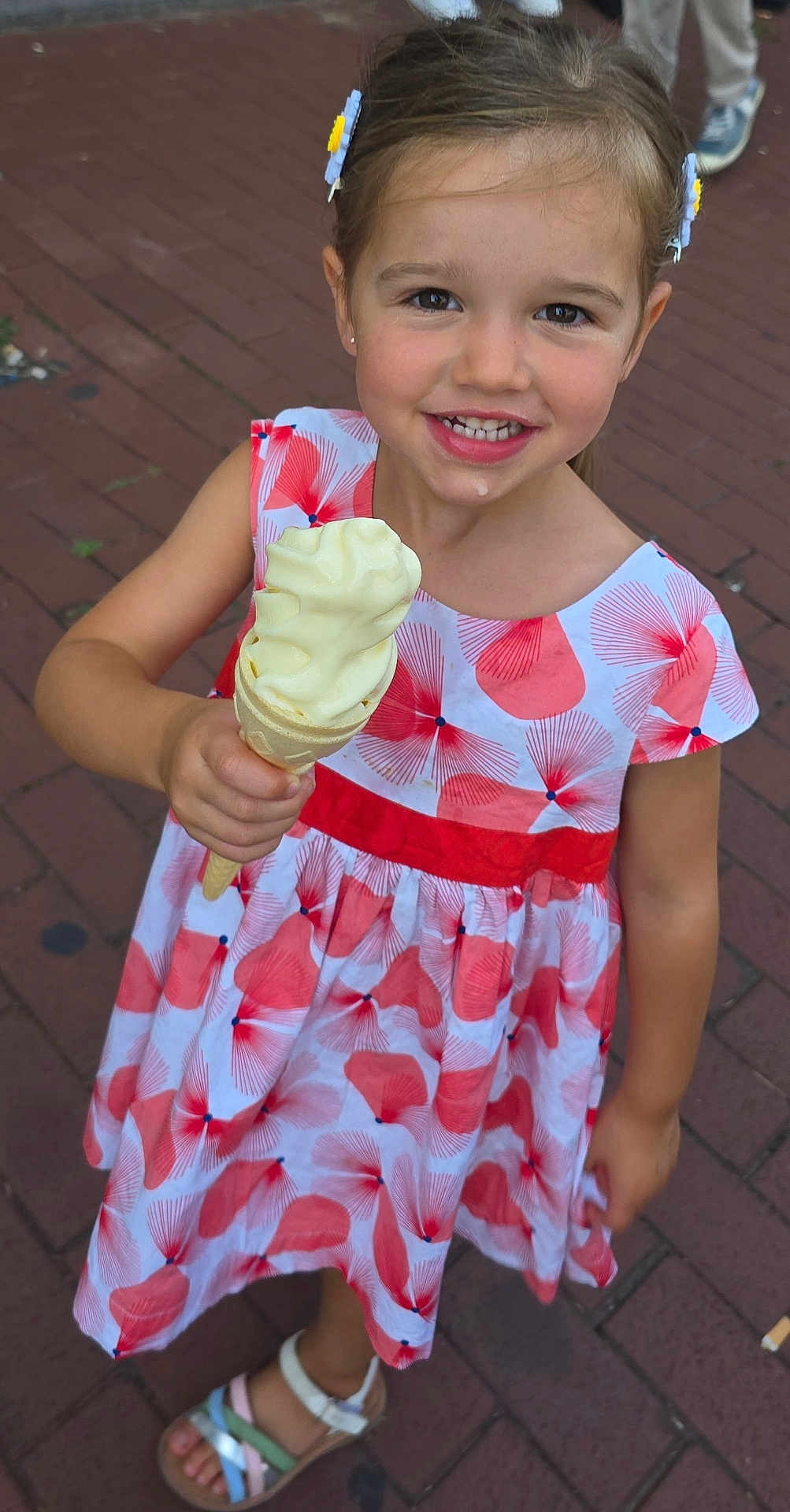 Lyloo participe au concours pour gagner de l'argent avec cette photo : child, confection, daylight, dress, face, food, footwear, girl, hair_clips, hand, happy, ice_cream, outdoor, patterned_dress, pavement, person, sandals, smile, summer, sweet