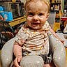 baby, bib, blonde_hair, blue_eyes, child, close_up, crumbs, food, happy, high_chair, home, indoors, infant, kitchen, meal, messy, portrait, shirt, sitting, smiling
