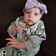 Myla joined the competition — help win amazing prizes! baby, child, infant, bow, headwear, onesie, clothing, pattern, cartoon, couch, furniture, seated, hand, face, eyes, expression, indoor, portrait, cute, young