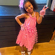 Nevaeh is registered to the contest to win money with this photo: child, girl, pink_dress, gloves, smile, peace_sign, curly_hair, headband, pearl_necklace, white_shoes, wooden_floor, cabinet, window, indoor, fashion, happy, posing, accessories, playful, confident