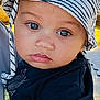 toddler, child, hat, striped_hat, black_shirt, face, eyes, outdoor, daylight, tree, grass, portrait, close_up, expression, baby, skin, person, headwear, summer, cute