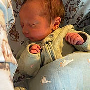 Maxwell is registered to the contest to win money with this photo: newborn, baby, sleeping, blanket, swaddled, infant, cozy, patterned_fabric, cute, peaceful, clothing, soft, indoors, resting, child, portrait, tiny_hands, face, head, closeup