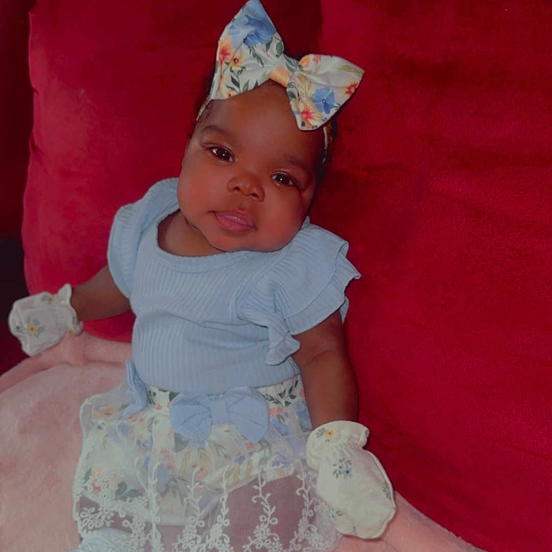 Nymeria is registered to the contest to win money with this photo: architecture, baby, bonnet, building, clothing, couch, cushion, diaper, face, furniture, hat, head, homedecor, indoors, livingroom, person, photography, portrait, room, sitting