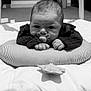 baby, infant, pacifier, cushion, striped, soft_toys, blanket, floor, carpet, radiator, indoors, child, cute, lying_down, black_and_white, clothing, hands, head, face, room
