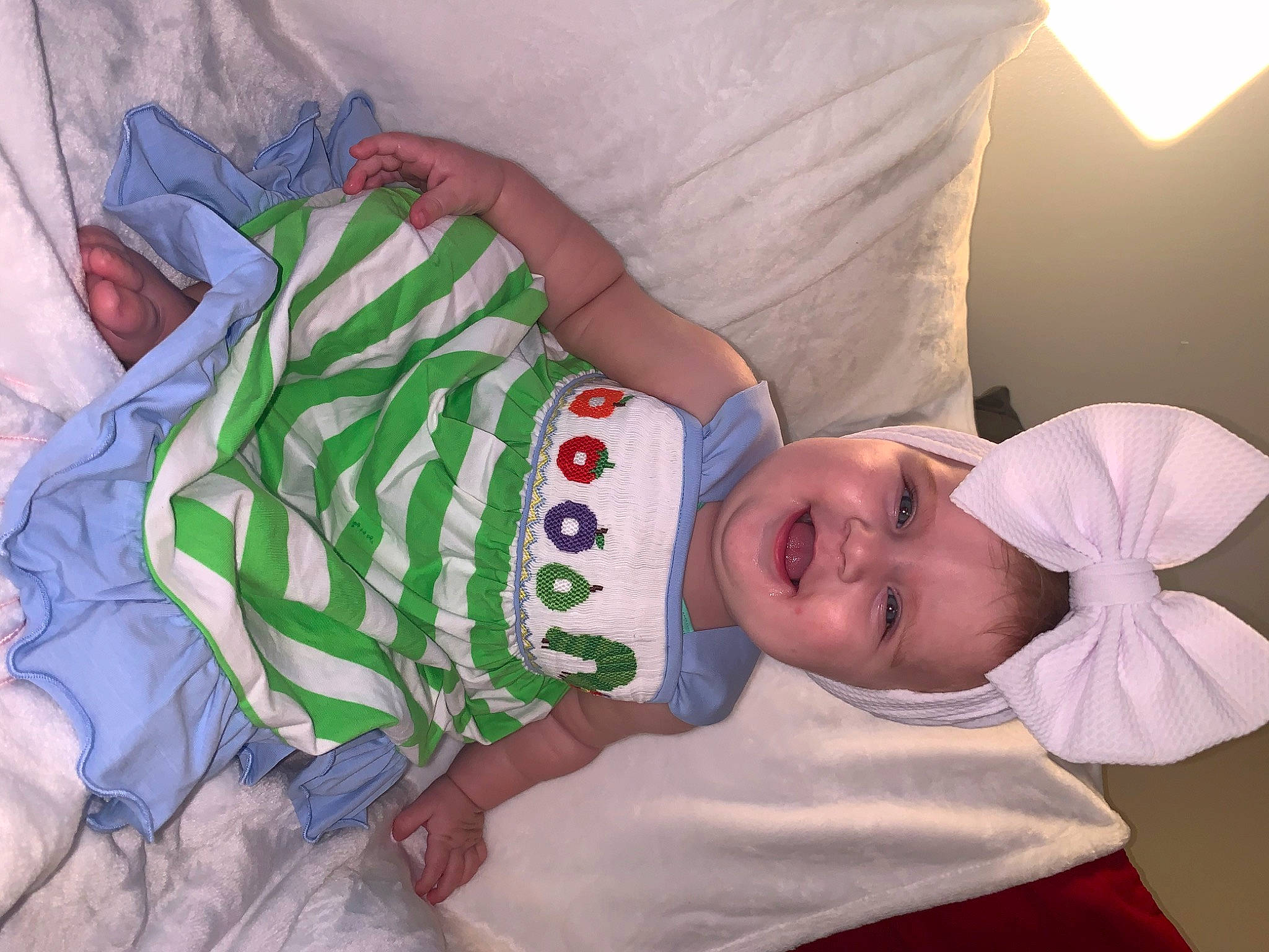 Sadie Mae is registered to the contest to win money with this photo: baby, baby_products, baby_toddler_clothing, child, comfort, event, facial_expression, finger, hand, happy, hat, headwear, human_body, joy, linens, pattern, person, room, skin, sleeve