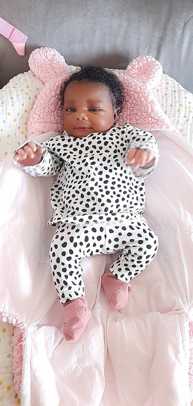 Stacy participe au concours pour gagner de l'argent avec cette photo : arm, baby, baby_toddler_clothing, child, doll, eye, hand, head, linens, nail, pattern, person, pink, product, skin, sleeve, textile, thigh, toddler, toy