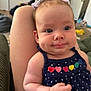 Nora is registered to the contest to win money with this photo: baby, child, infant, portrait, face, expression, cheeks, clothing, dress, hearts, polka_dots, person, skin, arm, hand, hair, bow, indoor, furniture, leg