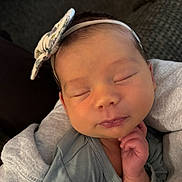 Nora joined the competition — help win amazing prizes! baby, newborn, sleeping, headband, bow, hand, face, clothing, blanket, cozy, infant, peaceful, portrait, closeup, cute, skin, person, resting, indoors, soft