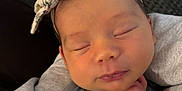 Nora joined the competition — help win amazing prizes! baby, newborn, sleeping, headband, bow, hand, face, clothing, blanket, cozy, infant, peaceful, portrait, closeup, cute, skin, person, resting, indoors, soft