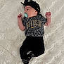 baby, newborn, pacifier, headband, nike, clothing, black_clothing, socks, blanket, soft_texture, infant, lying_down, cute, sleepwear, patterned_clothing, leopard_print, child, portrait, resting, indoors