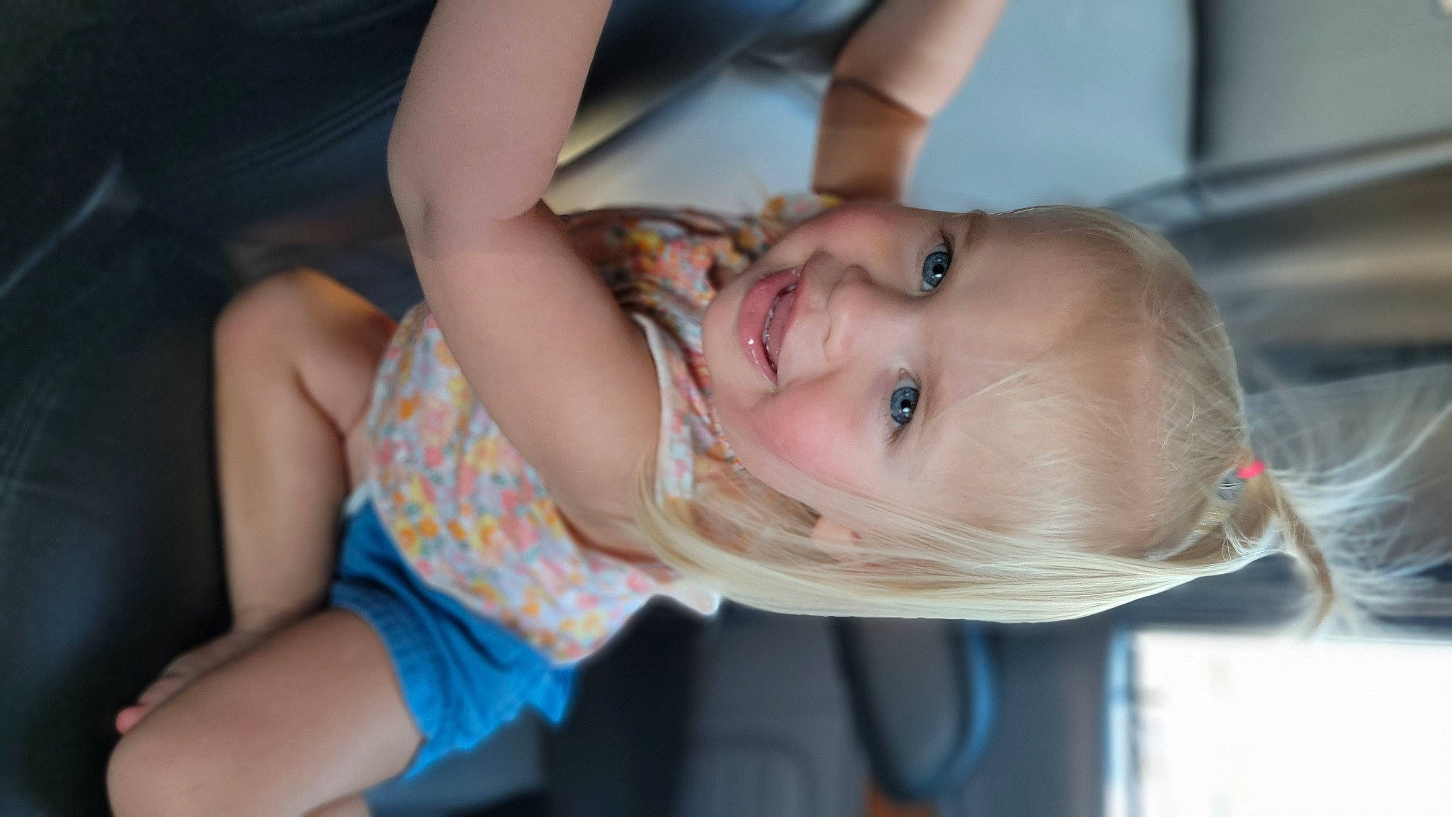 Macy is registered to the contest to win money with this photo: baby, blond, cheek, child, elbow, event, fun, gesture, happy, iris, joy, leisure, lip, mouth, nose, person, sitting, skin, smile, thigh