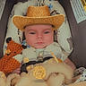 Mack joined the competition — help win amazing prizes! baby, infant, child, cowboy_hat, portrait, sitting, baby_seat, plush_toys, stuffed_animal, blanket, cushion, indoor, close_up, face, eyes, neutral_expression, cozy, photograph, caption, text_overlay