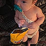 Mack is registered to the contest to win money with this photo: baby, infant, child, pacifier, diaper, sitting, portrait, face, eyes, hands, snack, chip_bag, packaged_food, blanket, indoor, close_up, candid, curious, light_skin, textured_fabric