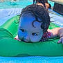 Serena is registered to the contest to win money with this photo: baby, child, pool, water, inflatable_ring, swimming, wet_hair, curly_hair, outdoor, summer, playful, floating, blue, green, skin, hand, cheeky, fun, sunlight, relaxation