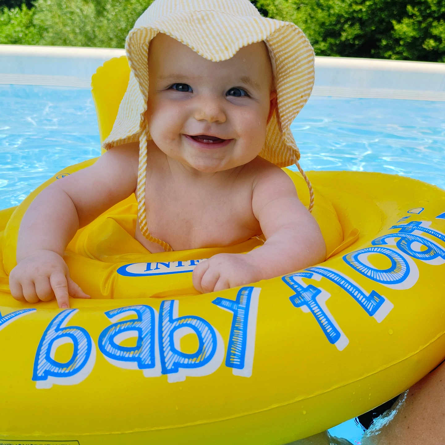 Alice participe au concours pour gagner de l'argent avec cette photo : baby, blue, child, cute, floating, green, happy, hat, infant, inflatable_ring, nature, outdoor, person, pool, smiling, summer, sun_hat, swimming_pool, water, yellow