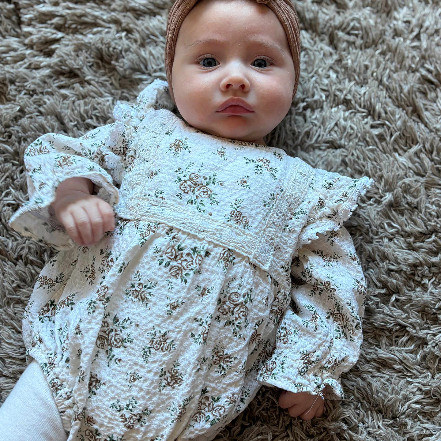 Arliah joined the competition — help win amazing prizes! baby, bow, carpet, child, cute, expression, face, floral_outfit, hands, headband, indoors, infant, legs, long_sleeves, lying_down, portrait, rug, soft_light, texture, white_clothing