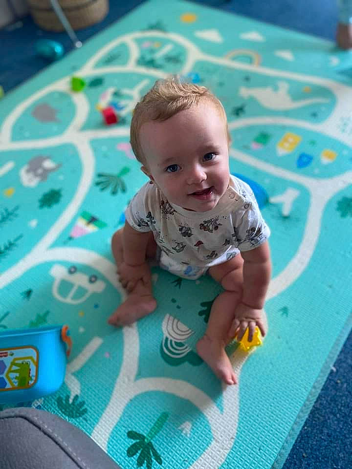 Knox joined the competition — help win amazing prizes! aqua, baby, baby_products, baby_toddler_clothing, blue, cheek, child, circle, floor, flooring, fun, grass, happy, leisure, pattern, person, play, playmat, sitting, smile