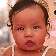 Jasmine participe au concours pour gagner de l'argent avec cette photo : baby, close_up, curly_hair, blue_eyes, necklace, white_tank_top, cute, portrait, face, child, indoor, soft_background, heart_shapes, chubby_cheeks, young_child, infant, skin, expression, person, photography