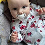 baby, pacifier, floral_onesie, blanket, star_pillow, moon_pillow, infant, cute, lying_down, hand, face, blue_eyes, soft_toys, patterned_blanket, indoor, close_up, child, newborn, comfortable, sleepwear