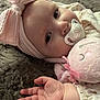 baby, infant, pacifier, headband, pink_bow, plush_toy, soft_blanket, hand, face, sleepwear, closeup, cute, child, indoor, resting, portrait, calm, furry, toy, comfort