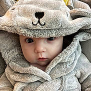 Renesmae is registered to the contest to win money with this photo: baby, child, infant, face, eyes, hood, clothing, plush, soft, cute, portrait, apparel, warm, expression, young, indoors, fabric, bundle, closeup, adorable