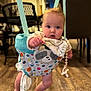 Blythe is registered to the contest to win money with this photo: baby, indoor, jumper, child, floor, wooden_floor, curious, face, expression, cloth, suspension, toy_pattern, footwearless, infant, person, home, furniture, chair, blanket, playtime