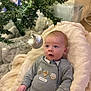 Frankie is registered to the contest to win money with this photo: baby, infant, child, blanket, christmas_tree, ornament, holiday, striped_clothing, indoor, cozy, soft_texture, decorations, festive, cute, face, person, seasonal, celebration, warm, young
