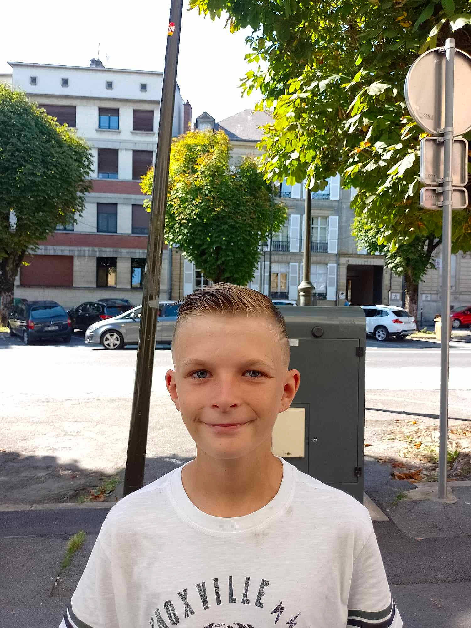 Donovan participe au concours pour gagner de l'argent avec cette photo : asphalt, car, city, daytime, eyewear, joy, leaf, neighbourhood, pedestrian, person, plant, public_space, road, road_surface, sidewalk, smile, street_light, t_shirt, tire, tree