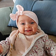Valéria a rejoint le concours — aidez-le/la à gagner de superbes lots ! apparel, baby, bow, child, closeup, clothing, cozy, cushion, cute, face, happy, headband, indoors, infant, person, pink, portrait, sitting, smile, soft