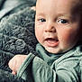 baby, child, face, eyes, blanket, fuzzy, cozy, infant, portrait, close_up, skin, expression, mouth, hand, clothing, soft, warm, indoors, young, cute
