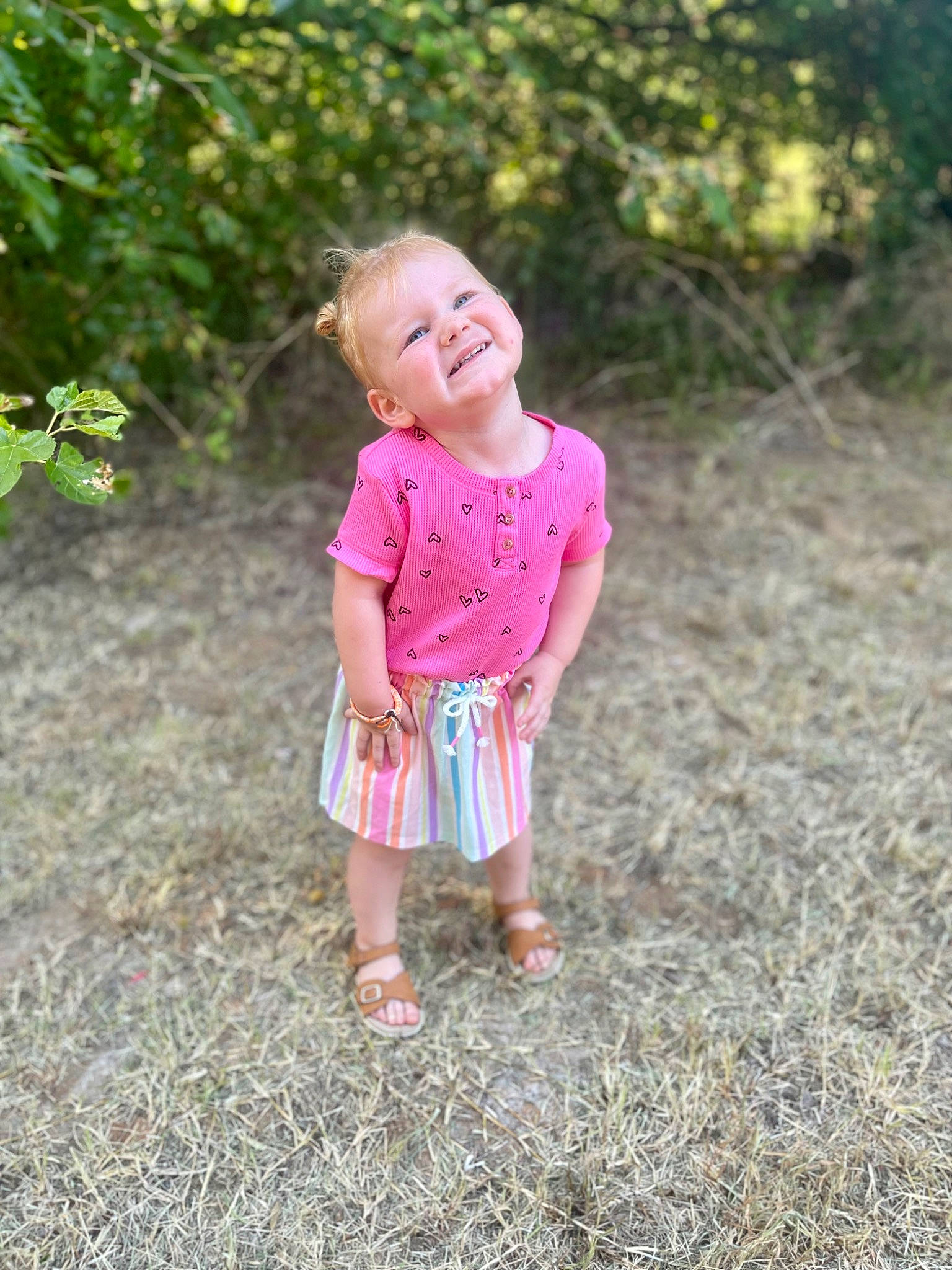 Brinley is registered to the contest to win money with this photo: arm, baby_toddler_clothing, clothing, dress, eye, face, grass, grass_family, happy, head, human_body, joy, leg, leisure, people_in_nature, person, plant, sleeve, smile, t_shirt