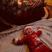 Giovanni Caputo is registered to the contest to win money with this photo: baby, christmas, holiday, festive, smiling, infant, tree, ornaments, lights, red_clothing, santa_hat, blanket, indoors, celebration, joy, cute, smile, decoration, seasonal, happy