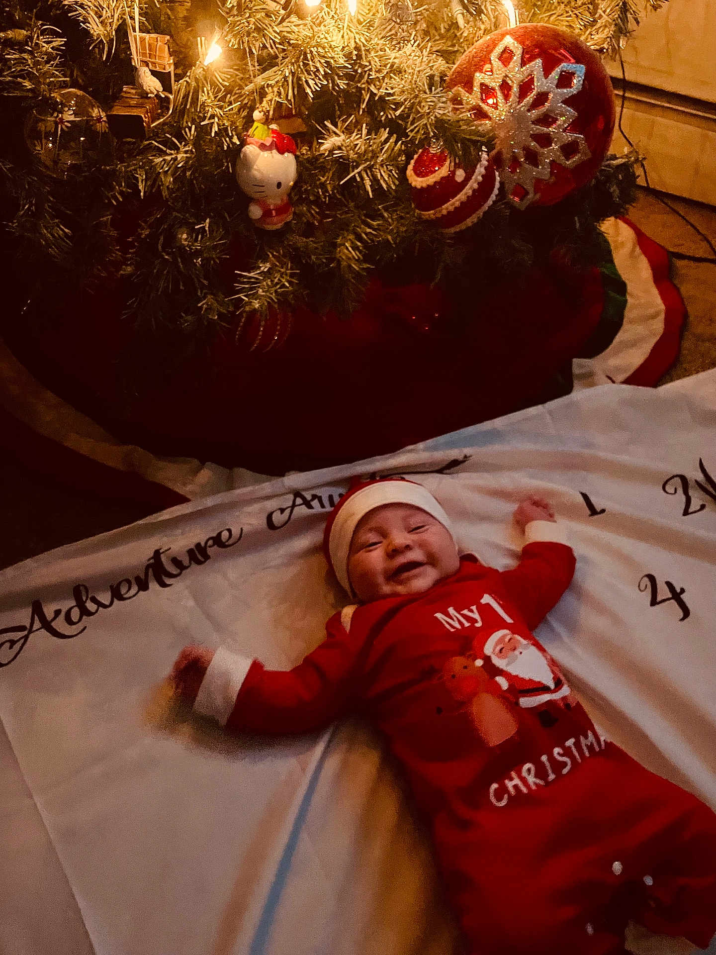 Giovanni Caputo is registered to the contest to win money with this photo: baby, christmas, holiday, festive, smiling, infant, tree, ornaments, lights, red_clothing, santa_hat, blanket, indoors, celebration, joy, cute, smile, decoration, seasonal, happy