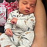 baby, sleeping, infant, onesie, animal_print, sock, arm, person, closeup, comfort, rest, cute, newborn, peaceful, cuddling, casual_clothing, indoor, portrait, tender, human