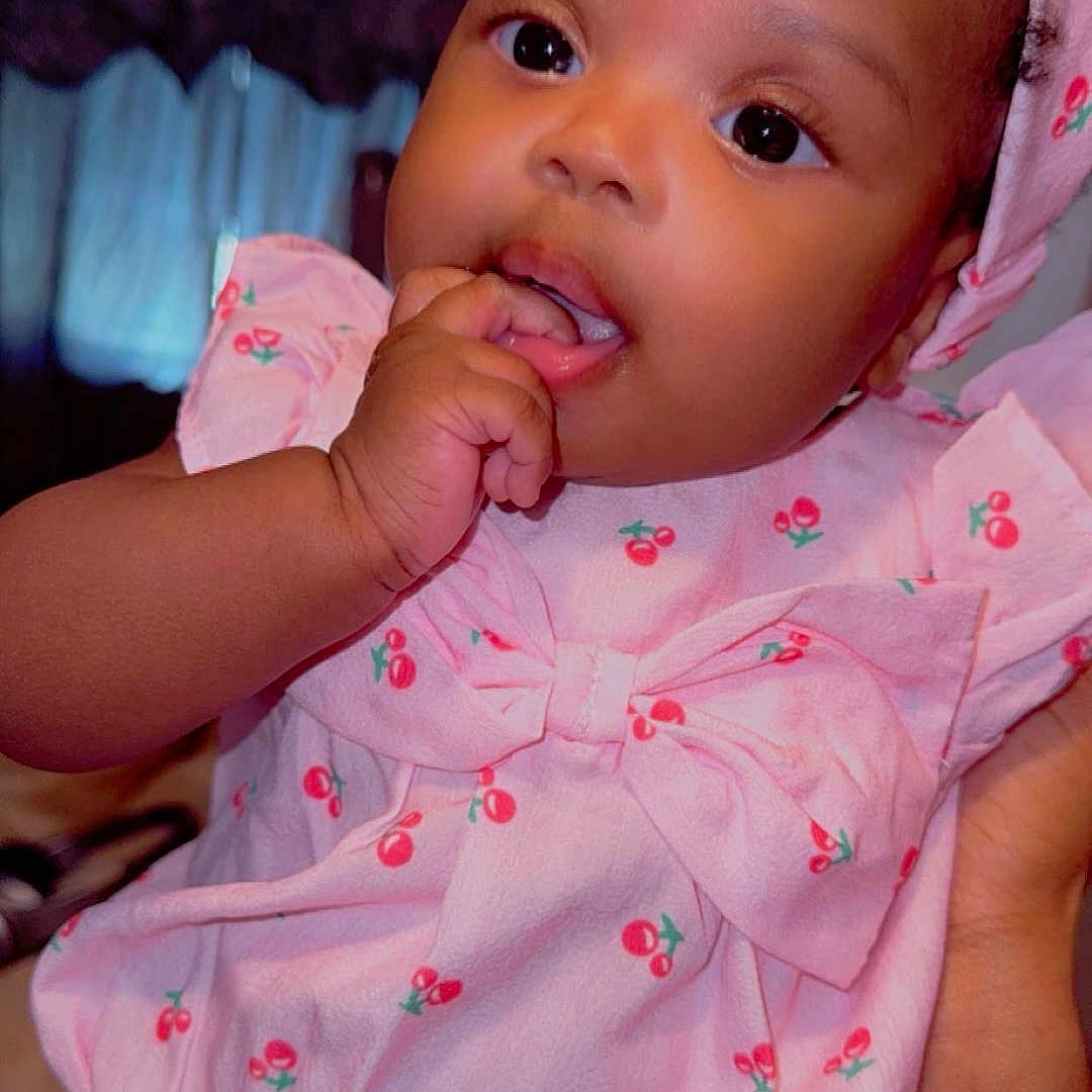 Steph-Danalia joined the competition — help win amazing prizes! adorable, baby, cherry_pattern, child, closeup, curious, cute, expression, fingers, hand, headband, human, indoor, infant, person, pink_clothing, portrait, skin, soft_lighting, young