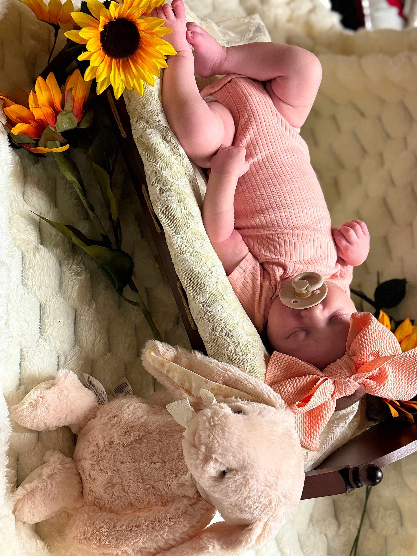 Poetri is registered to the contest to win money with this photo: baby, sleeping, pacifier, bow, plush_bunny, sunflower, basket, blanket, soft_toy, infant, cute, cozy, child, pink_outfit, headwear, resting, indoors, decor, portrait, peaceful