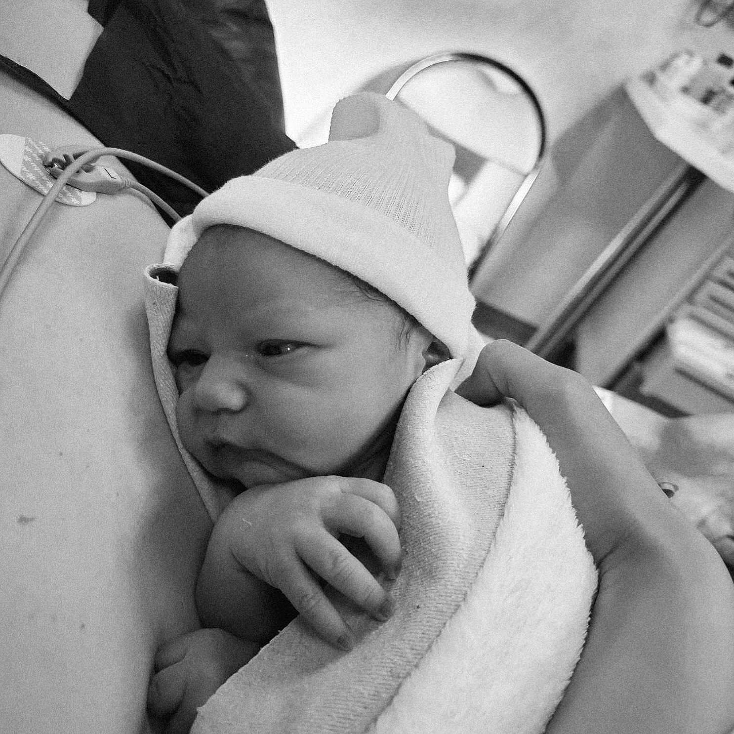 Eliott participe au concours pour gagner de l'argent avec cette photo : baby, black_and_white, blanket, cuddly, cute, face, hand, hat, holding, hospital, infant, intimate, new_life, newborn, peaceful, person, portrait, resting, skin, tender