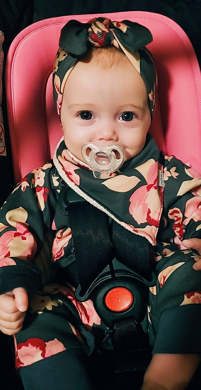 Rowan is registered to the contest to win money with this photo: baby, baby_products, baby_toddler_clothing, cheek, child, chin, event, eye, facial_expression, formal_wear, fun, happy, head, headwear, iris, person, pink, red, sitting, skin