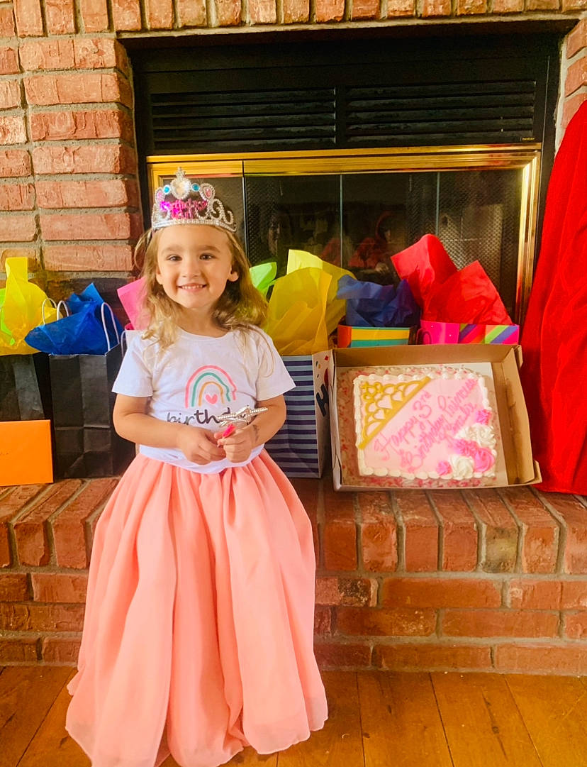 Kinzlie is registered to the contest to win money with this photo: box, child, costume, dress, entertainment, event, flooring, formal_wear, fun, happy, headwear, joy, leisure, magenta, orange, party, peach, person, pink, recreation