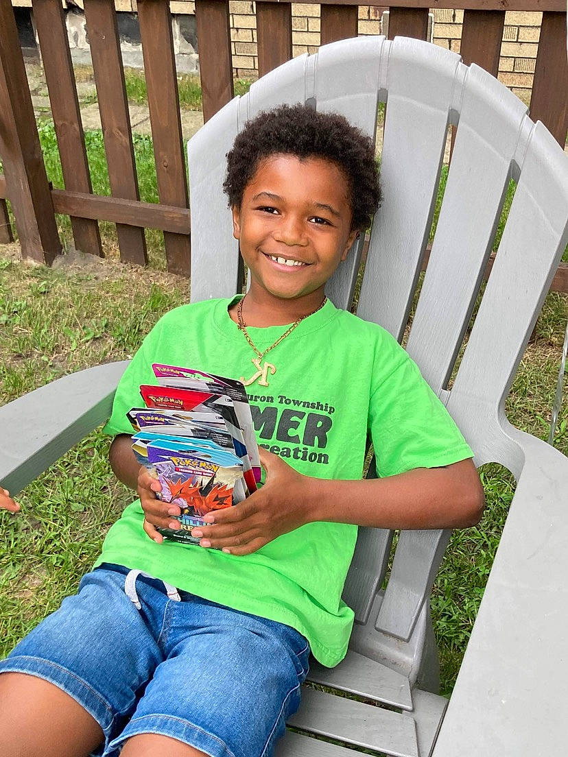 King is registered to the contest to win money with this photo: chair, clothing, fun, grass, green, happy, jeans, joy, lap, lawn, leisure, outdoor_furniture, people, person, plant, recreation, shirt, shorts, smile, summer