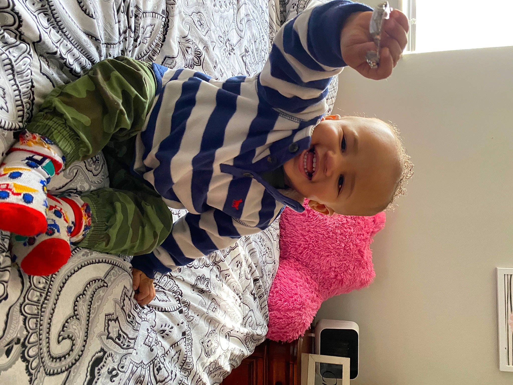 Phoenix is registered to the contest to win money with this photo: arm, baby, child, event, fun, happy, hat, holiday, leisure, linens, pajamas, pattern, person, play, room, sitting, sleeve, smile, toddler, tree