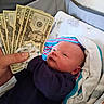 baby, infant, child, face, eyes, portrait, lying_down, blanket, clothing, newborn, indoor, bed, cushion, money, dollar_bills, hand, adult_hand, home, colorful_blanket, photography