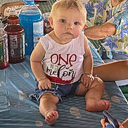 Anastasia joined the competition — help win amazing prizes! baby, child, infant, person, table, bottle, clothing, tank_top, shorts, hand, phone, elderly_person, glasses, floral_shirt, blue_tablecloth, picnic, indoor, sitting, curious, family_gathering