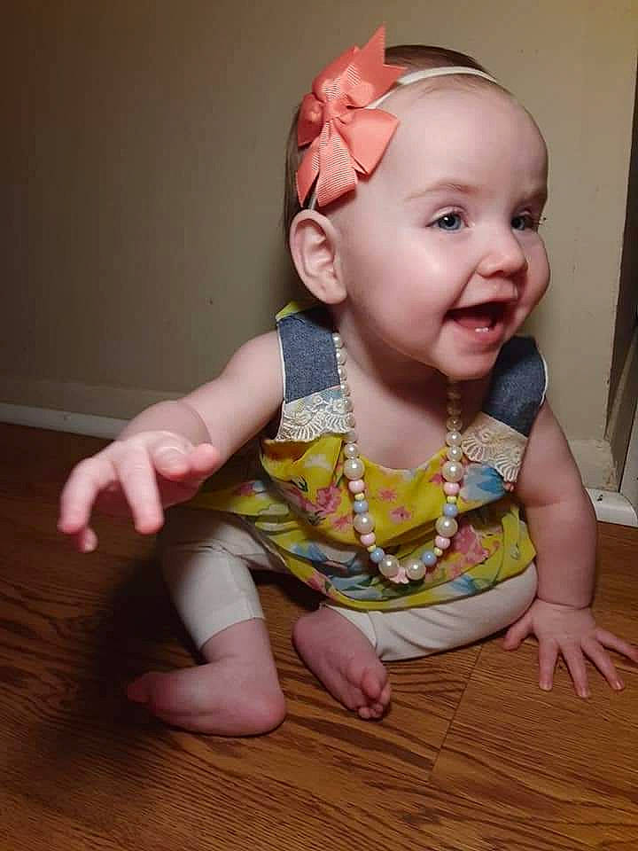 Palaris is registered to the contest to win money with this photo: baby, baby_toddler_clothing, cheek, child, finger, hair_accessory, head, headband, headwear, person, sitting, skin, smile, toddler, wood