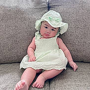 Emma-Rose joined the competition — help win amazing prizes! baby, infant, child, portrait, sitting, couch, furniture, sunhat, dress, white_clothing, barefoot, toes, face, serious_expression, indoors, home, textile, soft_lighting, closeup, photography