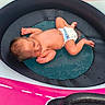 baby, close_up, colorful, diaper, face, hair, indoor, infant, lying_down, mesh_mat, newborn, photography, pink, portrait, relaxed, round_basin, skin, sleeping, turquoise, water_droplets